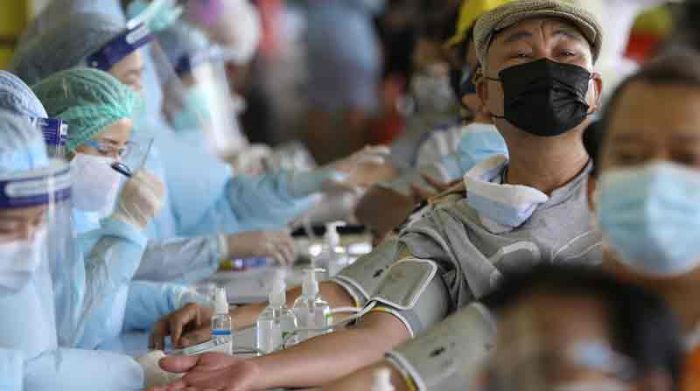 Los residentes controlan el pulso mientras se someten a una vacunación de emergencia contra la pandemia del coronavirus covid 19 en Bangkok, Tailandia. Foto: EFE