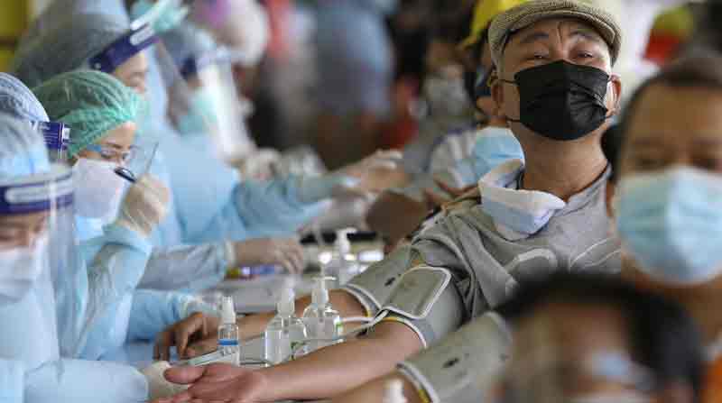 Los residentes controlan el pulso mientras se someten a una vacunación de emergencia contra la pandemia del coronavirus covid 19 en Bangkok, Tailandia. Foto: EFE