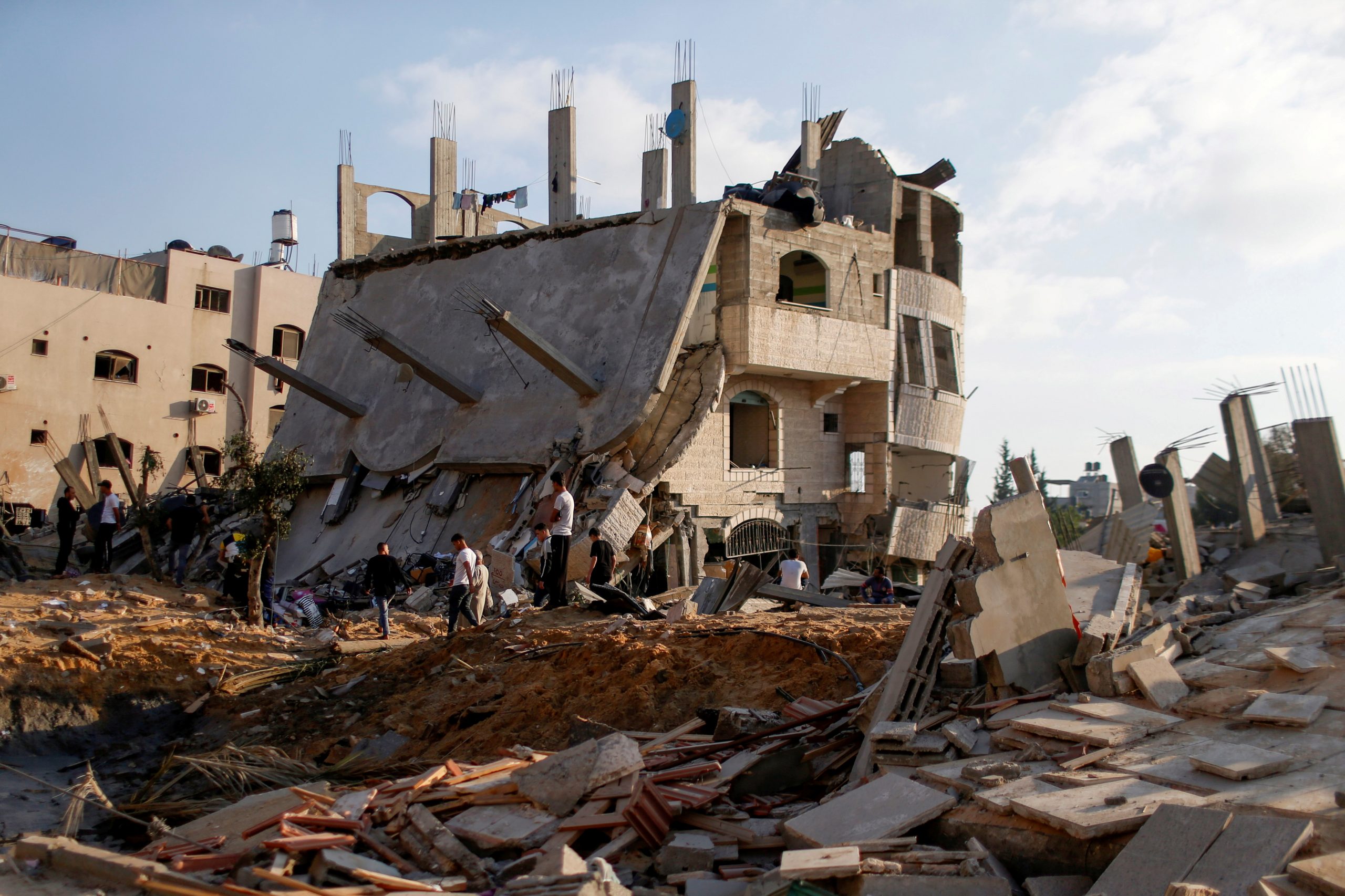 Palestinos se reúnen alrededor de las ruinas de los edificios que fueron destruidos por los ataques aéreos israelíes en medio de un estallido de violencia israelí-palestina, en el norte de la Franja de Gaza, el 13 de mayo de 2021. Foto: REUTERS