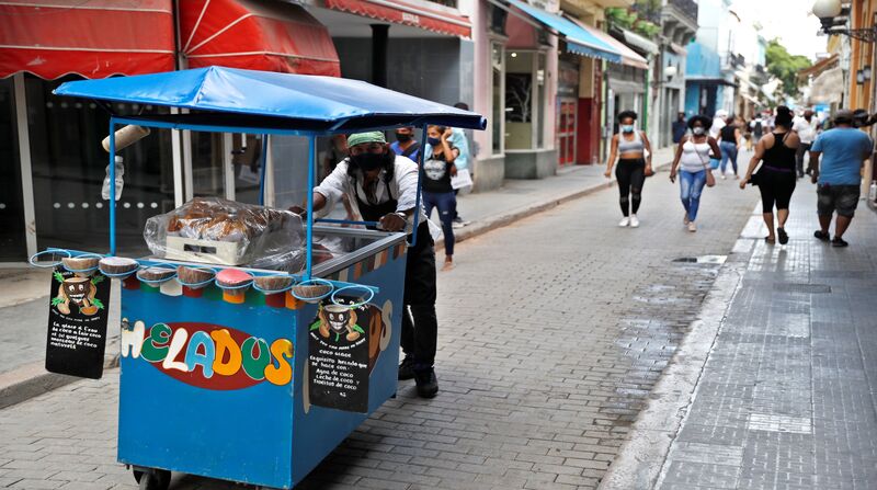 Un vendedor de helados recorre la calle Obispo, en La Habana (Cuba). Este sábado 8 de mayo de 2021, Cuba reportó más de un millar de contagios por covid-19 en un quinto día consecutivo. Foto: EFE