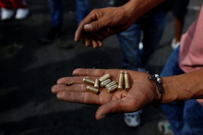 Un persona sostiene unos cartuchos de bala durante unas protestas el 11 de mayo de 2021 en el barrio Siloé, en Cali (Colombia). Foto: EFE