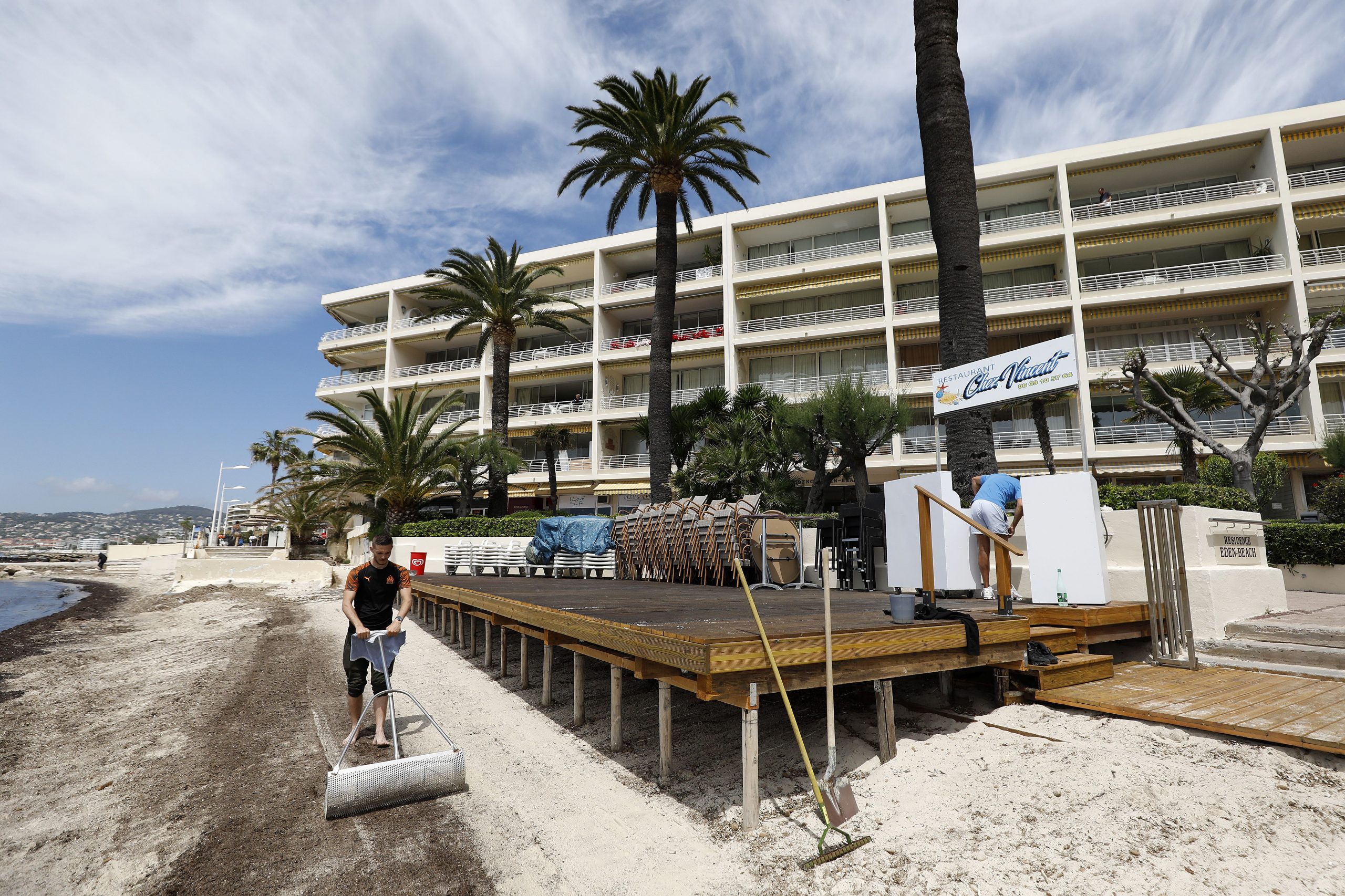 Un trabajador prepara una playa privada para la reapertura de las playas privadas, terrazas de restaurantes y bares en Antibes, Francia, el 18 de mayo de 2021. Foto: EFE