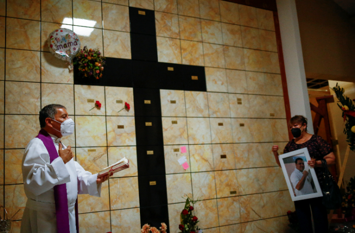 Un sacerdote brinda un servicio religioso a un médico que falleció a causa del covid-19 en México. Foto: REUTERS