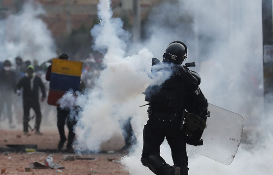Manifestantes y miembros del Escuadrón Móvil Antidisturbios (ESMAD) se enfrentan durante una jornada de protestas este 29 de mayo, en Madrid, municipio cercado de Bogotá (Colombia). Foto: EFE