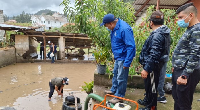 El domingo 16 de mayo del 2021 las personas y funcionarios realizaban trabajos para evacuar el agua y lodo que afectó viviendas en Cuenca. Foto: Cortesía