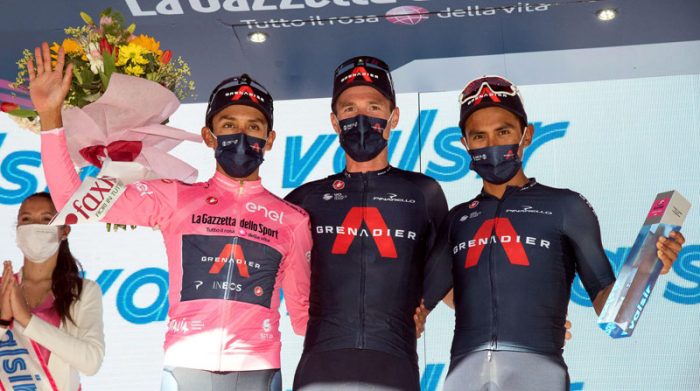 Egan Bernal (izq.) con la maglia rosa acompañado en el podio por sus compañeros Salvatore Puccio y Jhonatan Narváez (der.), el 17 de mayo del 2021. Foto: EFE