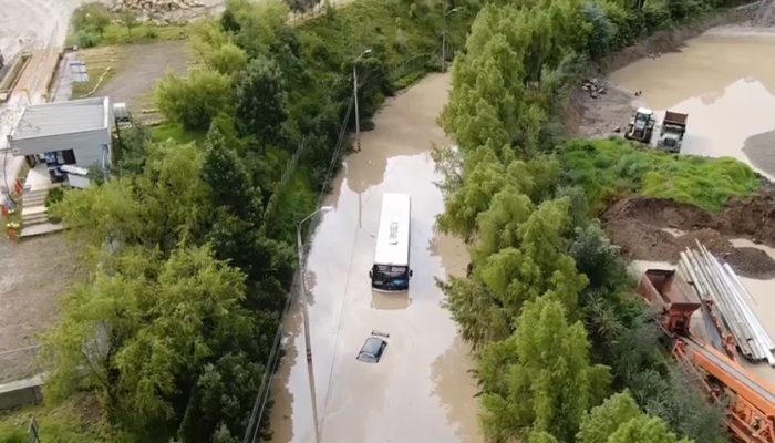 El bus y más vehículos quedaron en medio del agua, durante las fuertes lluvias en Cuenca. Foto: Cortesía Cuerpo de Bomberos de Quito