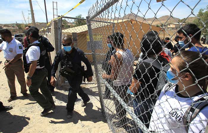 Agentes escoltan desde una casa a más de un centenar de indocumentados secuestrados en Ciudad Juárez, estado de Chihuahua (México). Foto: EFE