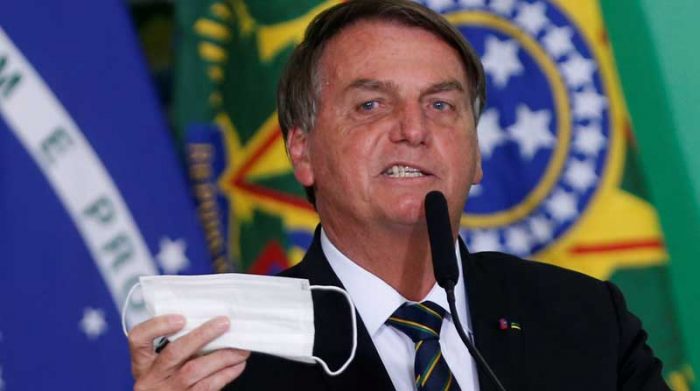 El presidente de Brasil, Jair Bolsonaro, sostiene su macarilla durante una ceremonia en el Palacio Planalto, en medio de la pandemia de covid19, en Brasilia, Brasil. Foto: REUTERS