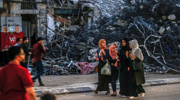 Los palestinos caminan en el vecindario de Al-Remal después de los ataques aéreos israelíes realizados en represalia por los militantes palestinos que lanzan dispositivos incendiarios adheridos a globos a los israelíes; en la ciudad de Gaza. Foto: EFE