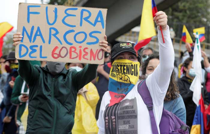 Manifestantes con pancartas y banderas de Colombia se reúnen en la vía que conduce al Aeropuerto Internacional EL Dorado en Bogotá. Foto: EFE