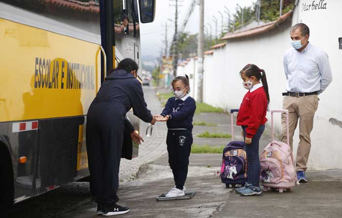 En Los Chillos, Sofía y Sara, de 9 y 6 años, esperaron el transporte, con su padre Mario. Foto: Diego Pallero / EL COMERCIO