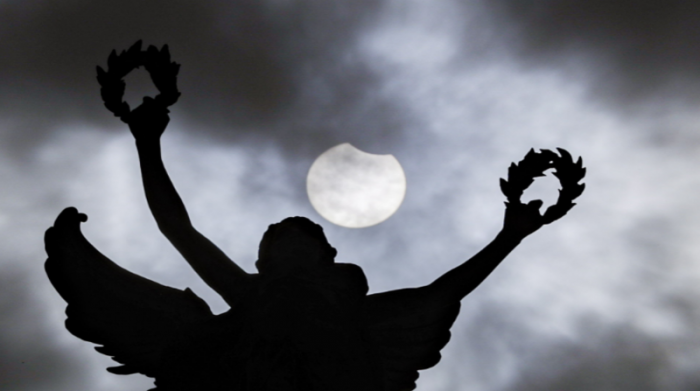 La estatua del parque Jubilee, en Bruselas, Bélgica, abre paso al eclipse, durante el día. Foto: EL COMERCIO