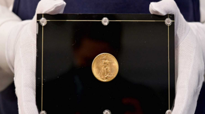 Un empleado de Sotheby's sostiene la "Mona lisa de las monedas" de 1933. Foto: AFP