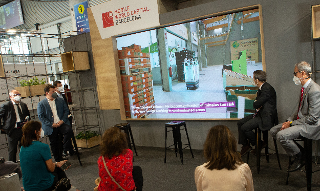 Varios visitantes asisten a la presentación de un robot que desinfecta grandes superficies con tecnología láser. Foto: EFE