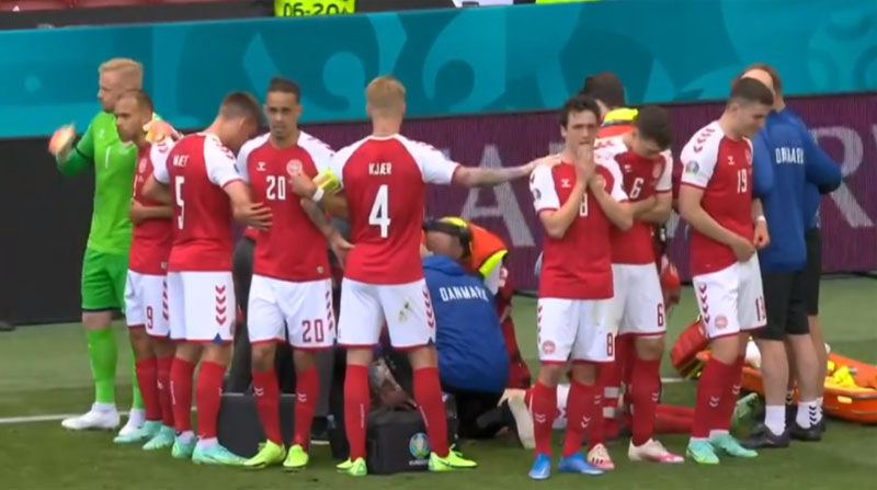 Jugadores de Dinamarca rodean a su compañero Christian Eriksen mientras es atendido de emergencia después de desplomarse en el cotejo de la Eurocopa ante Finlandia. Foto: captura de pantalla