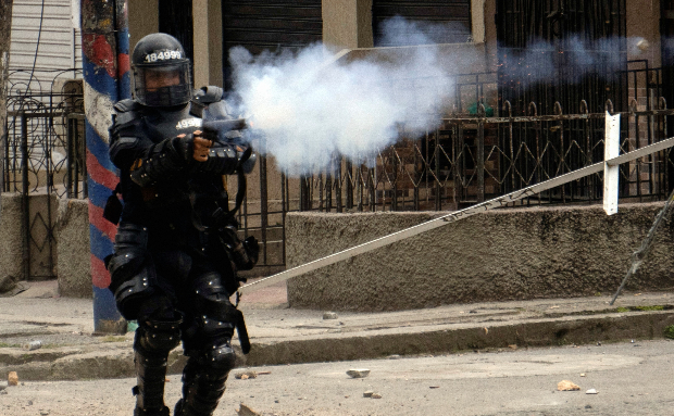 Un agente antidisturbios dispara una bomba lacrimógena el 14 de mayo del 2021 en Popayán, Colombia. Foto: REUTERSUn agente antidisturbios dispara una bomba lacrimógena el 14 de mayo del 2021 en Popayán, Colombia. Foto: REUTERS