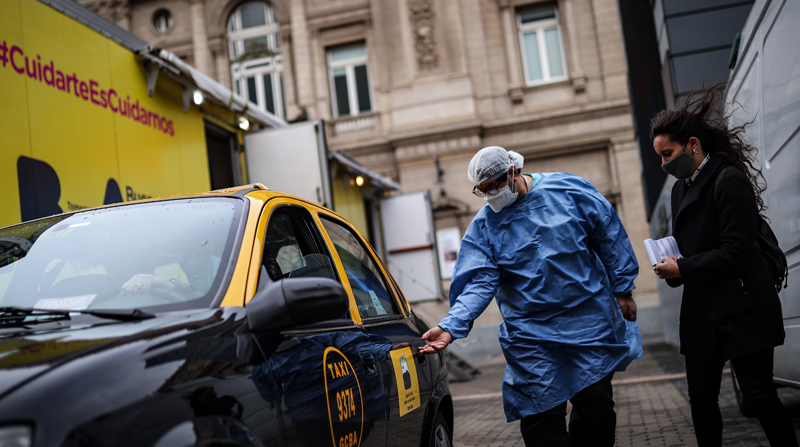 Una mujer se dispone a subirse a un taxi utilizado para el traslado de pacientes con covid-19, en Buenos Aires (Argentina). Foto: EFE