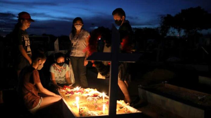 Familiares visitan la tumba de una víctima de covid-19 en Manaos, Brasil. Foto: REUTERS