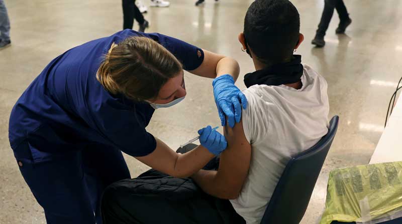Una persona recibe una dosis de la vacuna contra el covid-19 de Pfizer en un centro de vacunación masiva. Foto: REUTERS
