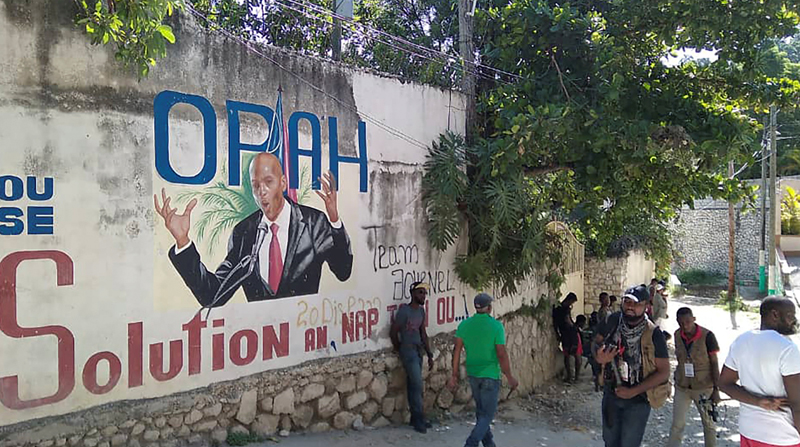Un grupo de personas pasando frente a un mural que muestra al presidente de Haiti, Jovenel Moise, tras su asesinato. Foto: REUTERS
