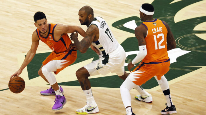 Devin Booker (izq.), de los Phoenix Suns, disputa el balón ante P.J. Tucker de los Milwaukee Bucks. Foto: EFE