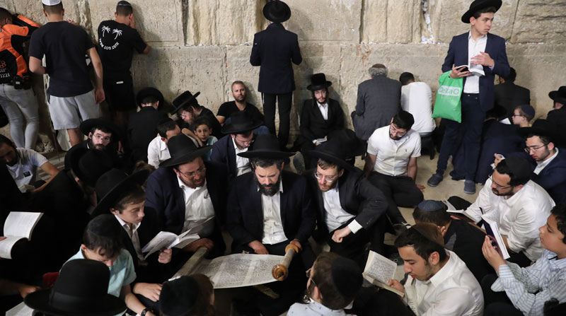 Los judíos ortodoxos oran mientras leen el libro de Eicha (libro de Lamentaciones) para conmemorar a Tisha B'av, en el Muro Occidental en Jerusalén. Foto: EFE