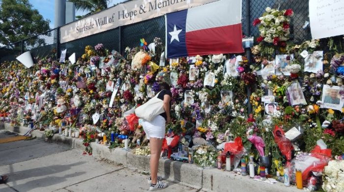 Varias personas visitan una valla dedicada a los desaparecidos en el derrumbe del edificio de condominios de 12 pisos en Surfside, este 3 de julio del 2021, en Florida (EE.UU.). Foto: EFE