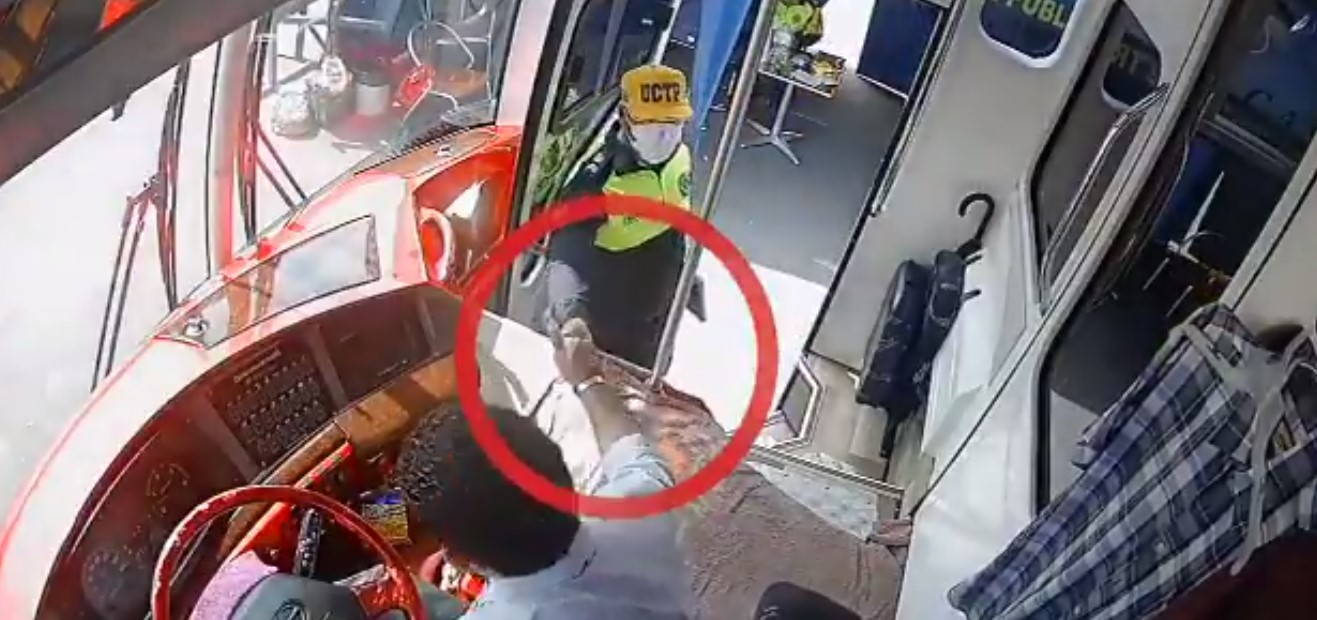 En la grabación se observa el momento en el que el agente cobra dinero al conductor de un bus, que labora en la Terminal Terrestre de Guayaquil. Foto: Captura de pantalla