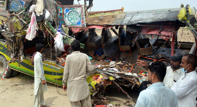 La gente se reúne alrededor de los restos de un autobús después de un accidente en Dera Ghazi Khan, Pakistán, el 19 de julio de 2021. Foto: EFE