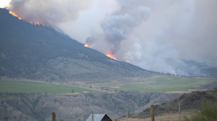 Una toma panorámica muestra humo y llamas ascendiendo sobre las colinas que rodean a la localidad de Lillooet, en la Columbia Británica, Canadá este 1 de julio del 2021. Sid Bones-Scotchman / via Reuters