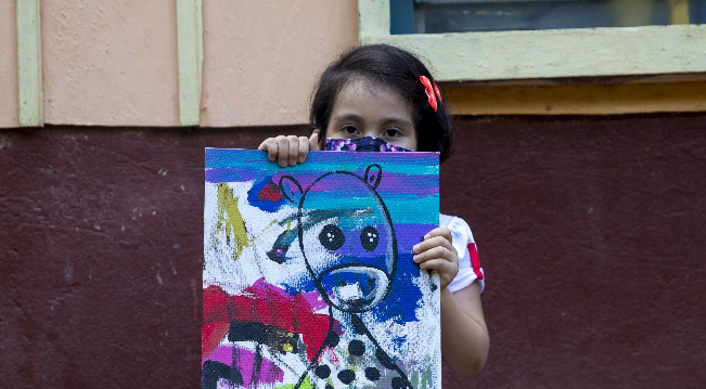 Kassandra Sánchez Espinoza muestra una de sus pinturas. Foto: EFE