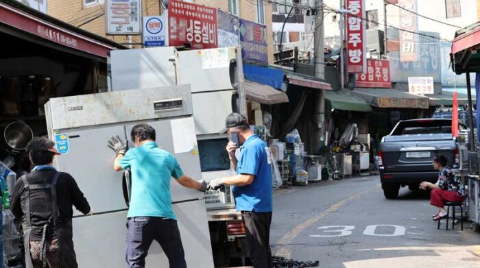 Los trabajadores mueven refrigeradores en un mercado de segunda mano mientras miles de salas de karaoke y pubs en todo el país cerraron sus negocios en medio de la pandemia, en Seúl, Corea del Sur. Foto: EFE