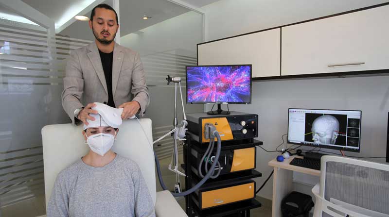 El médico José Cruz hace una demostración de la estimulación magnética transcraneal, con la psicóloga Lua Reyes. Foto: Julio Estrella / EL COMERCIO