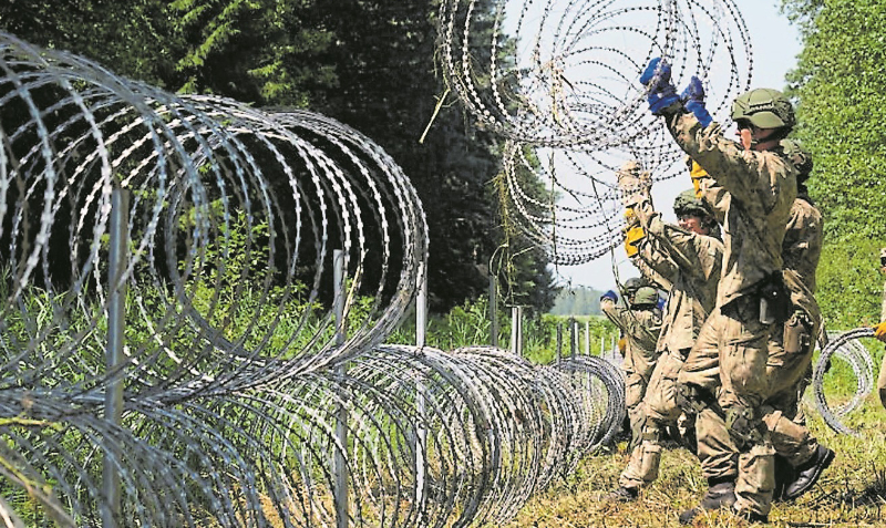 Soldados del ejército lituano instalan alambre de púas en la frontera con Bielorrusia, en Druskininkai. Foto: Reuters