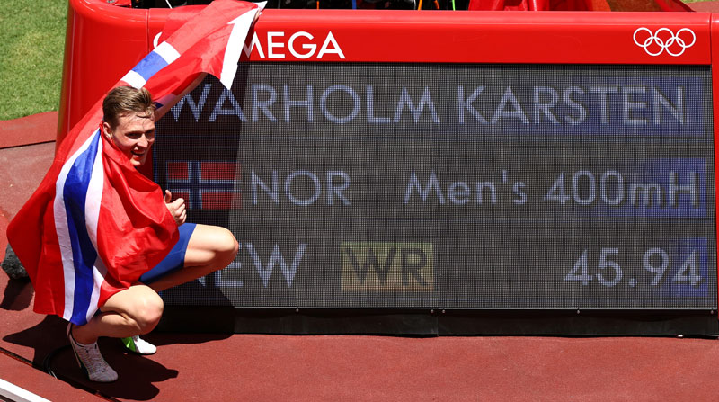 Karsten Warholm posa junto a su récord mundial con el que ganó la medalla de oro en 400 metros con vallas. Foto: Reuters