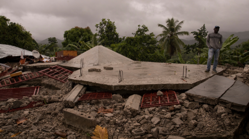 Luego del terremoto, el dolor no cesa. Un hombre camina sobre el techo de lo que fue una casa y tras las lluvias que dejó el paso de la tormenta Grace, el martes pasado, en Camp Perrin, una zona crítica tras el sismo. Foto: EFE