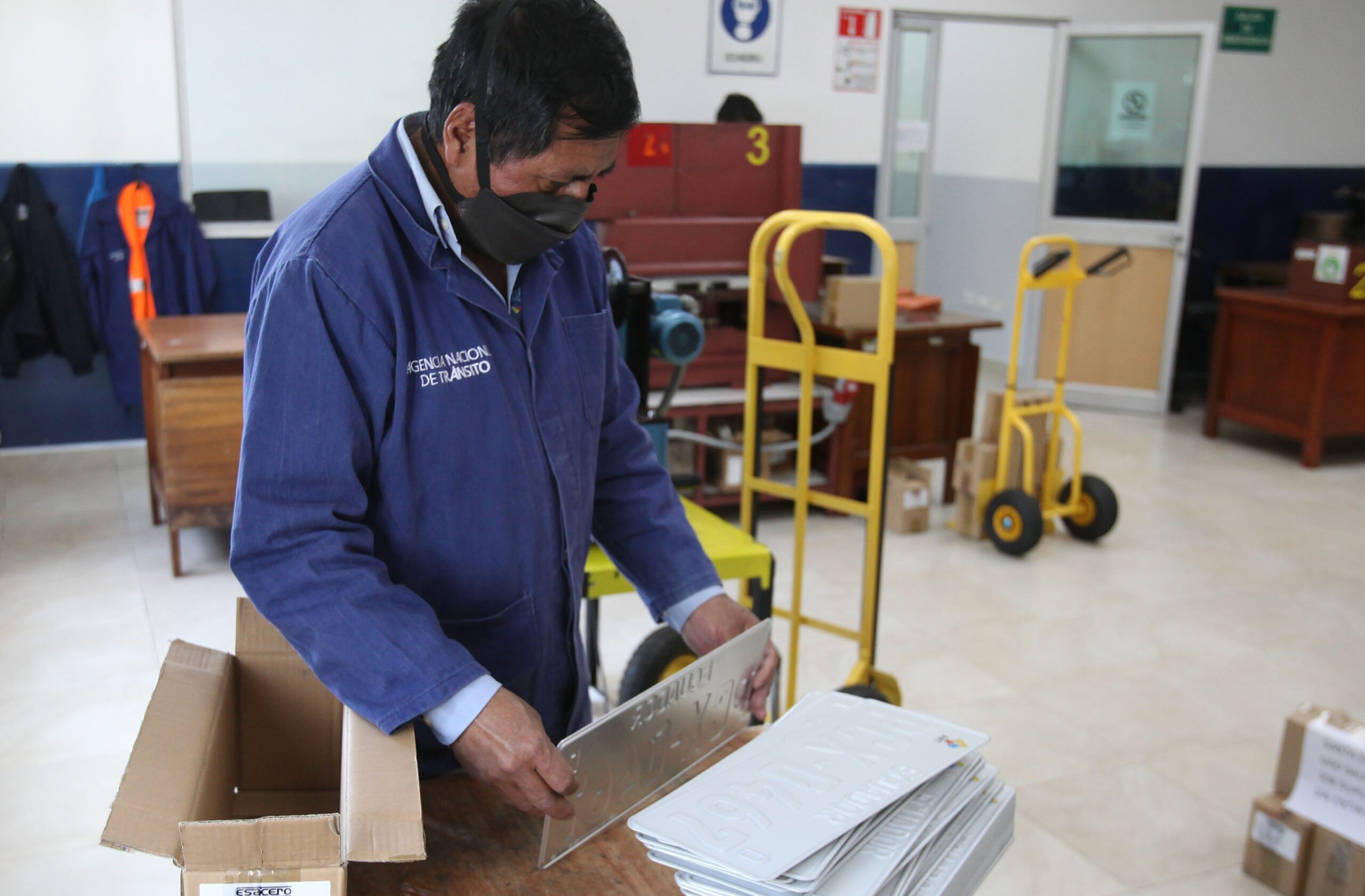 Un operador de la fábrica de la ANT apila las placas en blanco para guardarlas en una caja y embodegarlas. Foto: Julio Estrella / EL COMERCIO