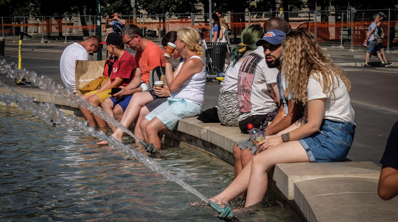 Personas se refrescan en una pileta de Piazza Castello, en Milán, por el calor que soporta Italia. Foto: EFE