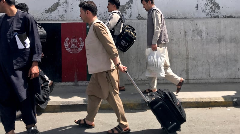 Cientos de afganos, algunos de ellos ministros y empleados gubernamentales y otros civiles -incluidos mujeres y niños- van a la terminal a la espera de vuelos. Foto: Reuters