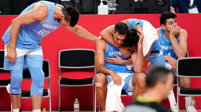 Jugadores de Argentina abrazan a Luis Scola (centro), quien anunció en Tokio su retiro de la selección de baloncesto. Foto: EFE