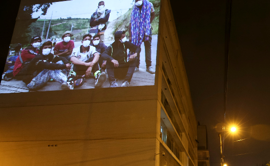 Fotografía de una exposición donde se muestran proyecciones de fotografías con los rostros de la migración en una de las paredes del Ministerio de Relaciones Exteriores, en Quito. Foto: EFE