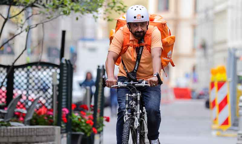 Mientras encuentra un trabajo, el exiministro Sayed Sadaat continúa aprendiendo alemán, reparte comida a domicilio con una bicicleta. Foto: Reuters