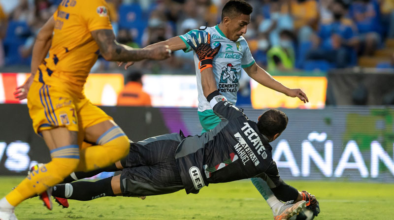 Nahuel Guzmán (abajo) portero de Tigres, disputa el balón con Ángel Mena (arriba) de León, durante un partido de la jornada 8 del Torneo Apertura 2021. Foto: EFE