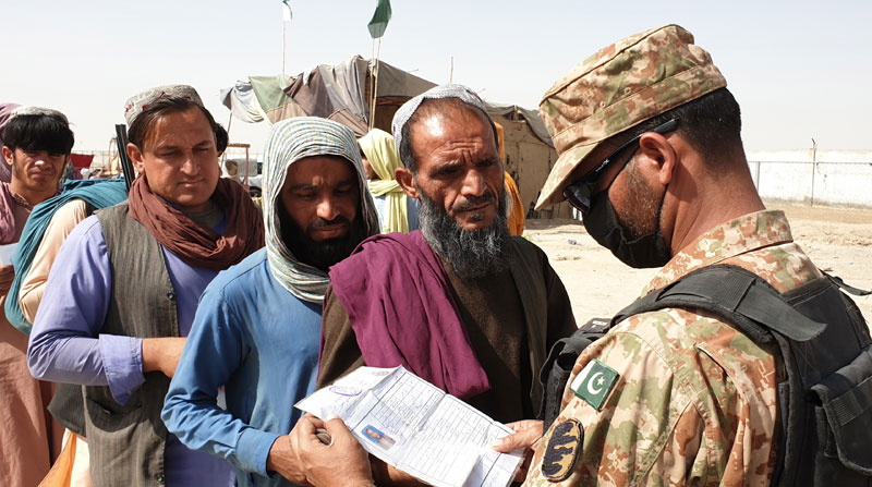 Un soldado de Pakistán controla la entrada de refugiados afganos a su territorio. Foto: EFE