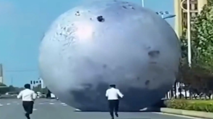 En el video se ve a la gran luna rodando por una calle, mientras dos hombres corren tras de ella para detenerla y evitar que genere un accidente. Foto: Captura de pantalla