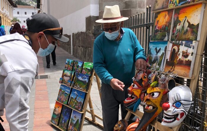 Segundo Pastuña expone máscaras de madera, en un tablero que coloca en la Sucre. Foto: Ana Guerrero / EL COMERCIO