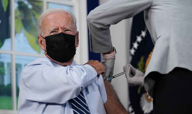 En un auditorio de la Casa Blanca, el presidente Joe Biden se remangó una manga de la camisa para que una enfermera le administrara la dosis de refuerzo. Foto: EFE