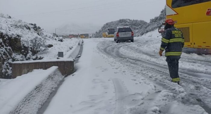Los Bomberos circularon a pie para brindar ayuda a las personas atrapadas en sus vehículos, por la fuerte nevada en la vía Quito- Papallacta. Foto: Cuerpo de Bomberos de Quito
