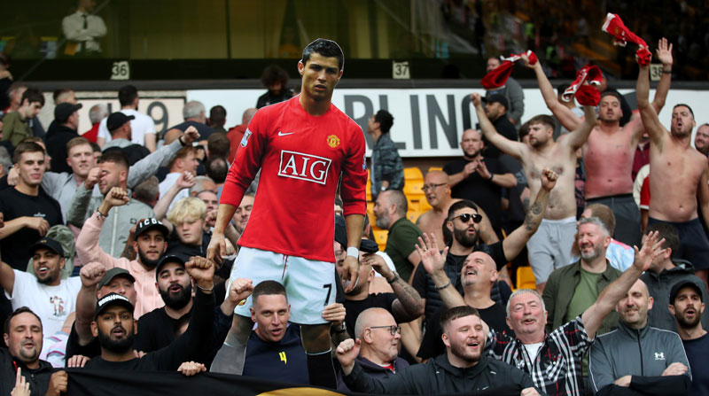 Foto de archivo de hinchas del Manchester United celebrando con un cartel de Cristiano Ronaldo tras la victoria sobre Wolverhampton Wanderers. Foto: Reuters